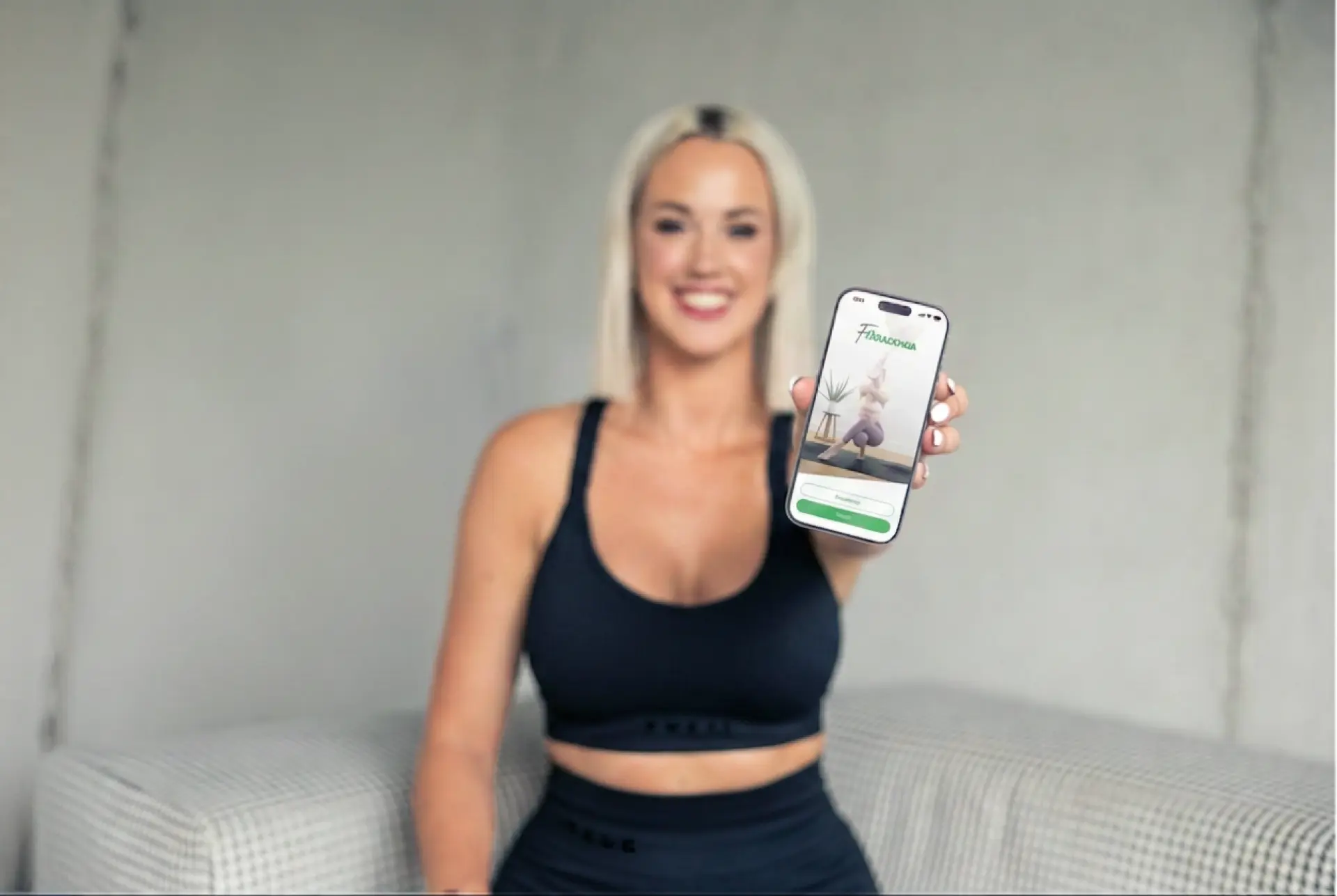 Ženska drži telefon z aplikacijo FA Base App